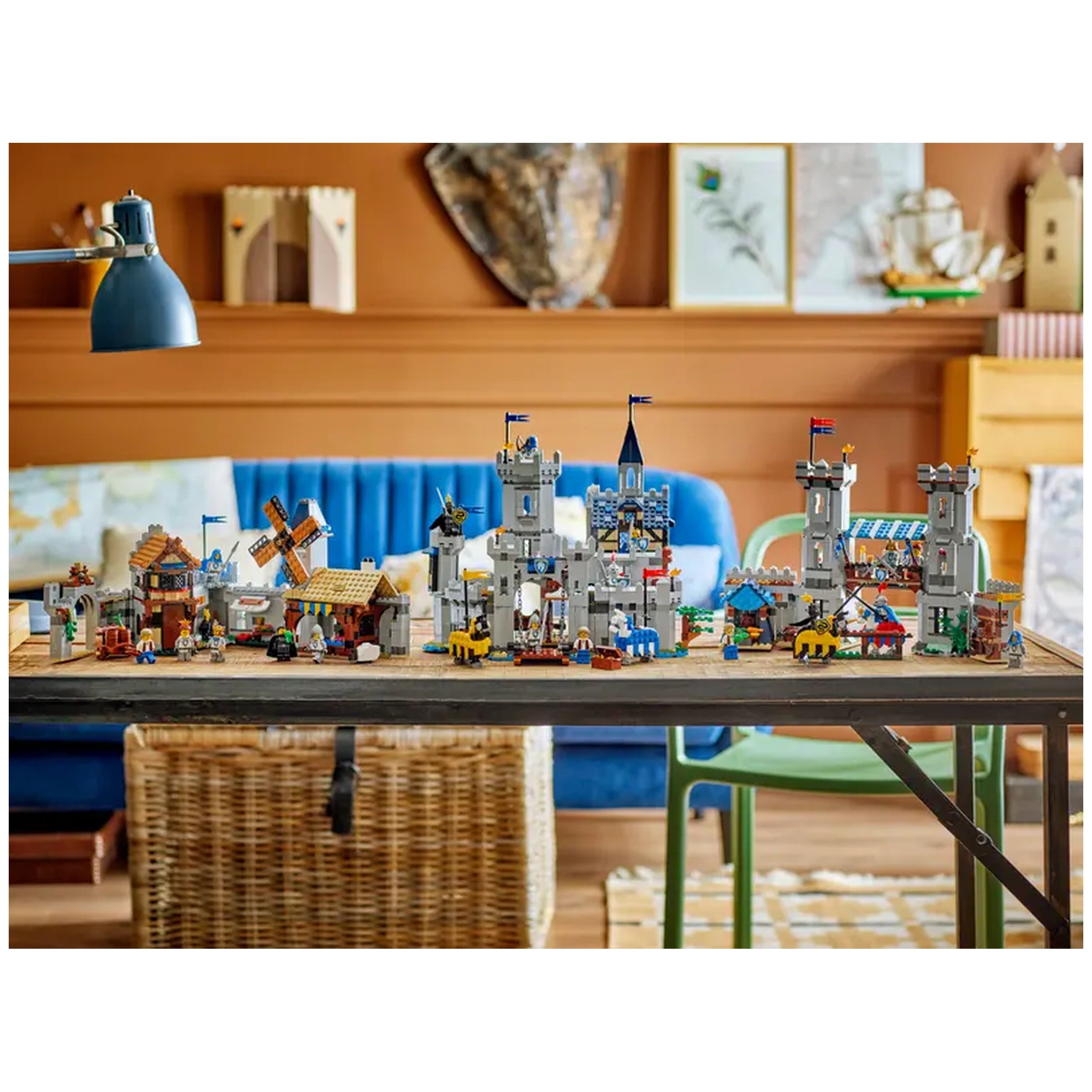 Colorful LEGO Creator 3in1 Medieval Horse Knight Castle set displayed on a wooden table, featuring towers, a windmill, and various medieval structures.