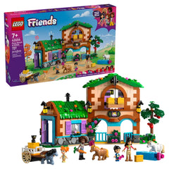 Colorful LEGO® Friends Pony Ranch & Stable set with two buildings, four characters, a pig, horses, and a cart. Features vibrant greenery and flowers.