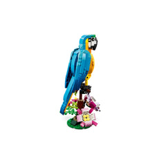 A colorful LEGO® Creator 3in1 Exotic Parrot perched on a tree branch, showcasing vibrant blue and yellow feathers against a green base with pink and yellow flowers.