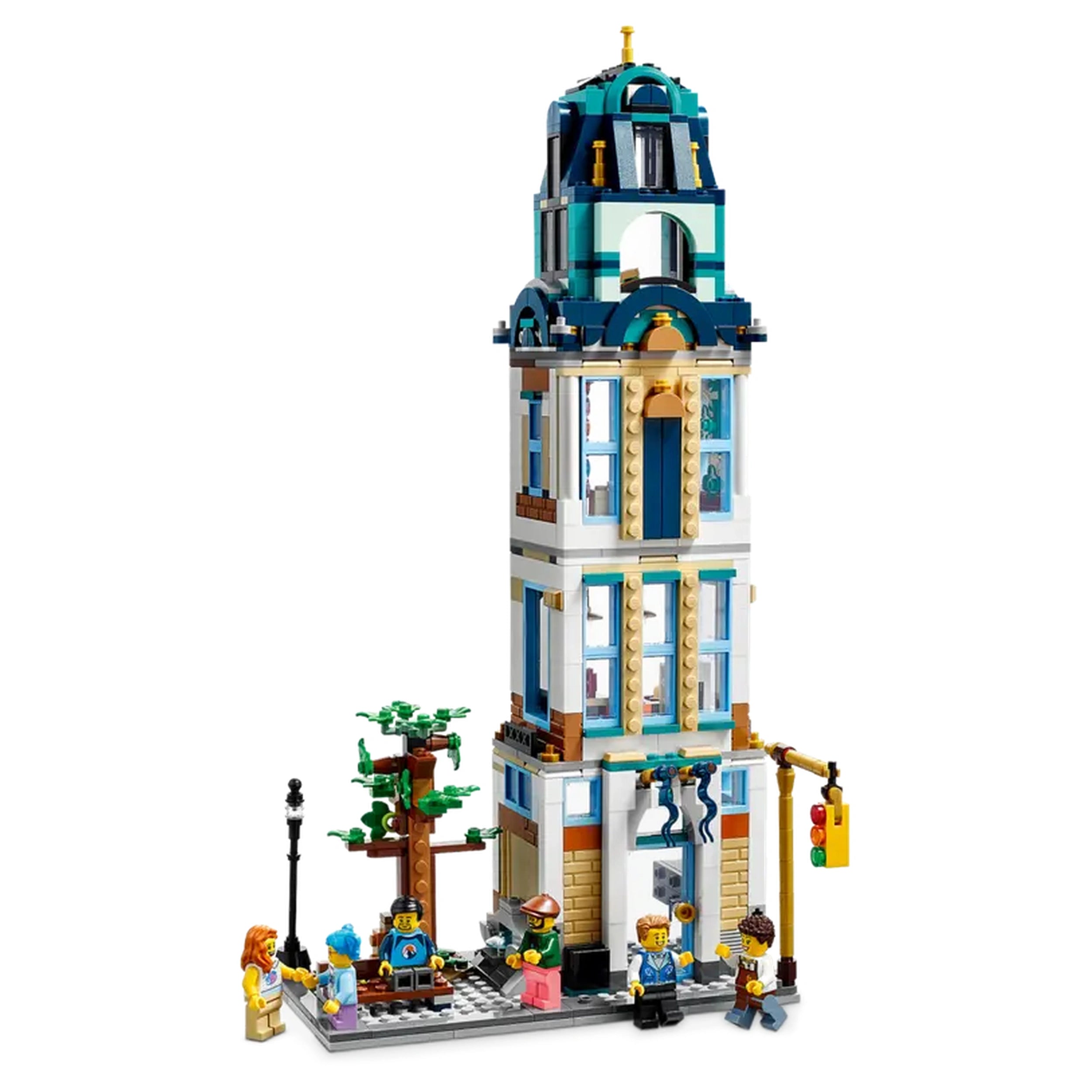 LEGO Creator 3in1 Main Street set features a tall, three-floor corner hotel with a blue domed roof, surrounded by colorful buildings. Minifigures are interacting near a tree and street lamp, while a traffic light is visible on the side. The playset showcases a vibrant city scene that invites imagination and storytelling.