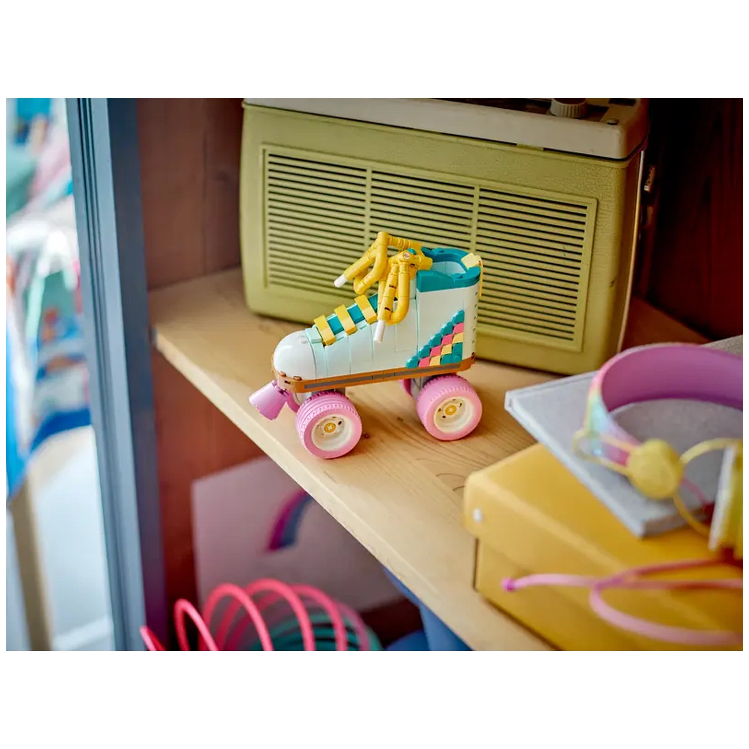 Colorful LEGO Creator Retro Roller Skate on a wooden shelf, featuring pink wheels, yellow laces, and a playful design.