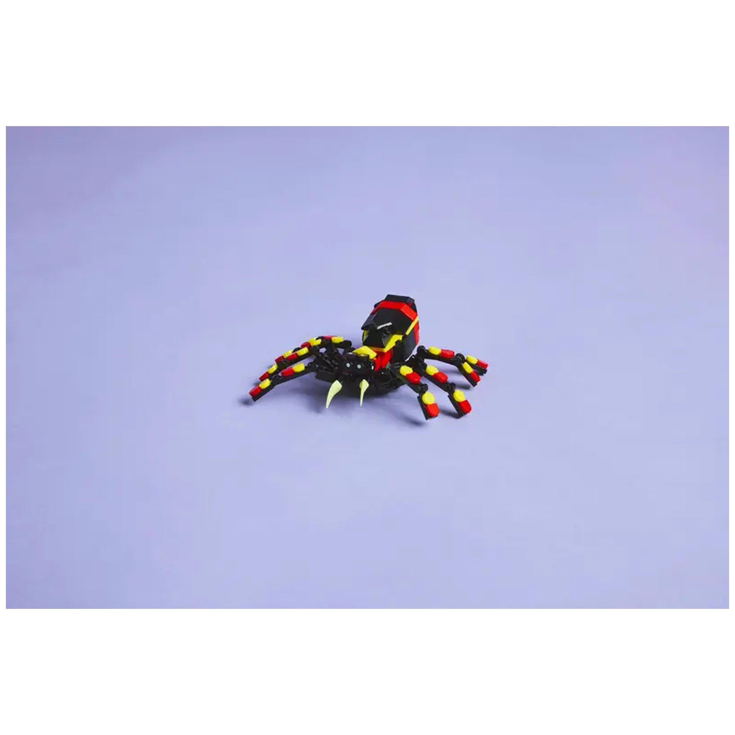 Posable LEGO Creator spider figure with eight articulated legs, bright red and yellow accents, and striking large teeth, set against a light purple background.
