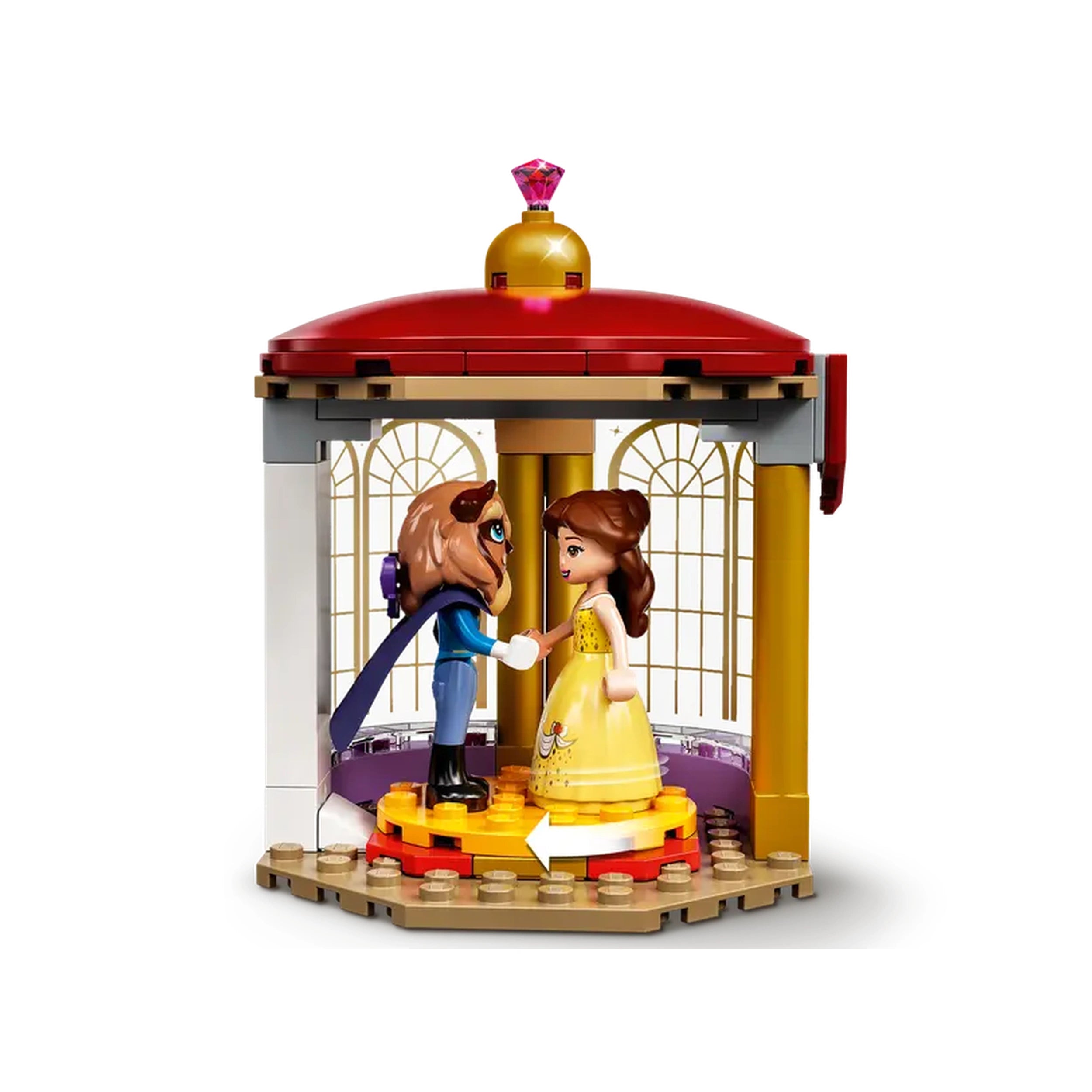 Belle and the Beast stand on a circular dance floor inside a two-story castle with golden windows, featuring a red roof and a jeweled crown on top.