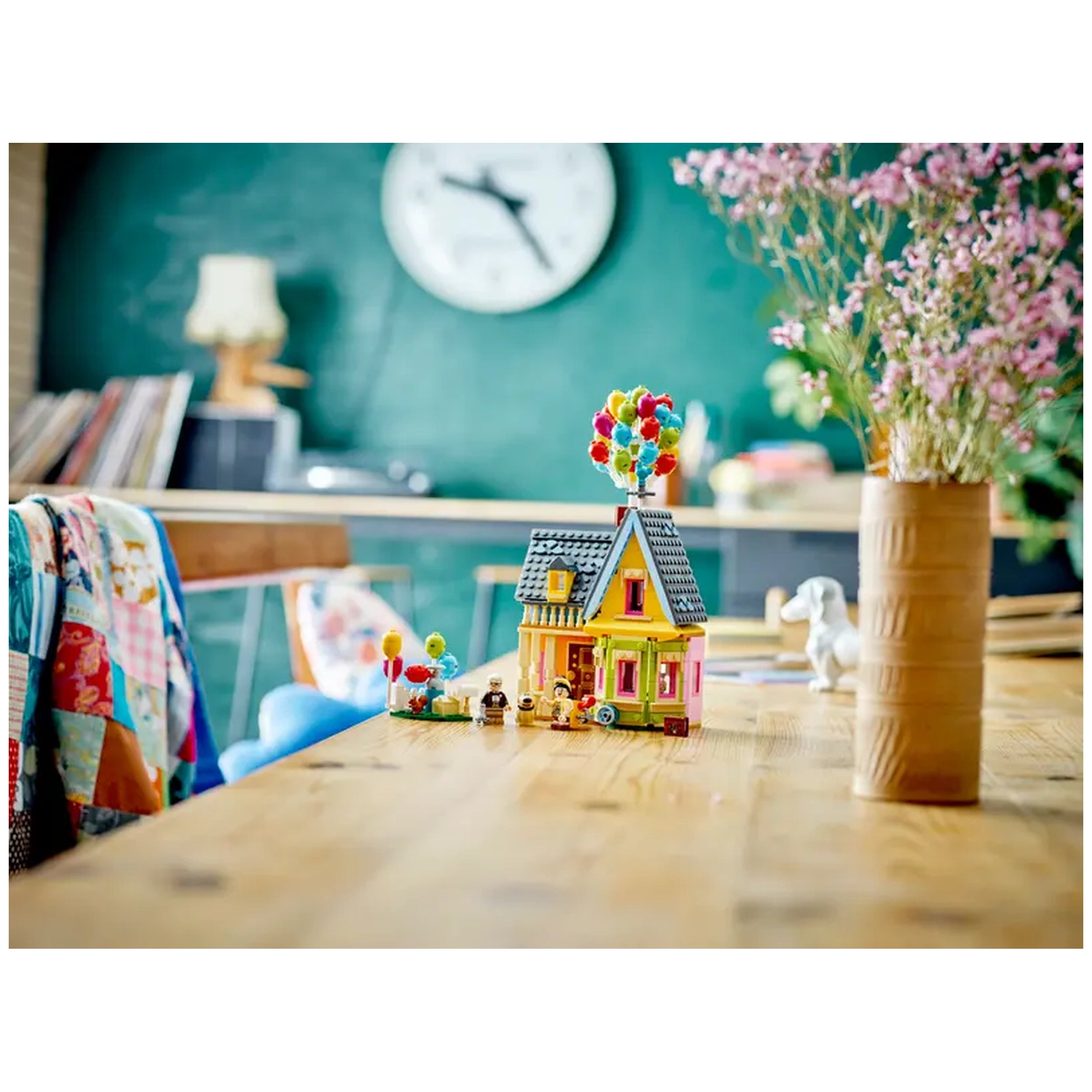 LEGO® Disney 'Up' House construction set on a wooden table, featuring colorful balloons and minifigures Carl and Russell.