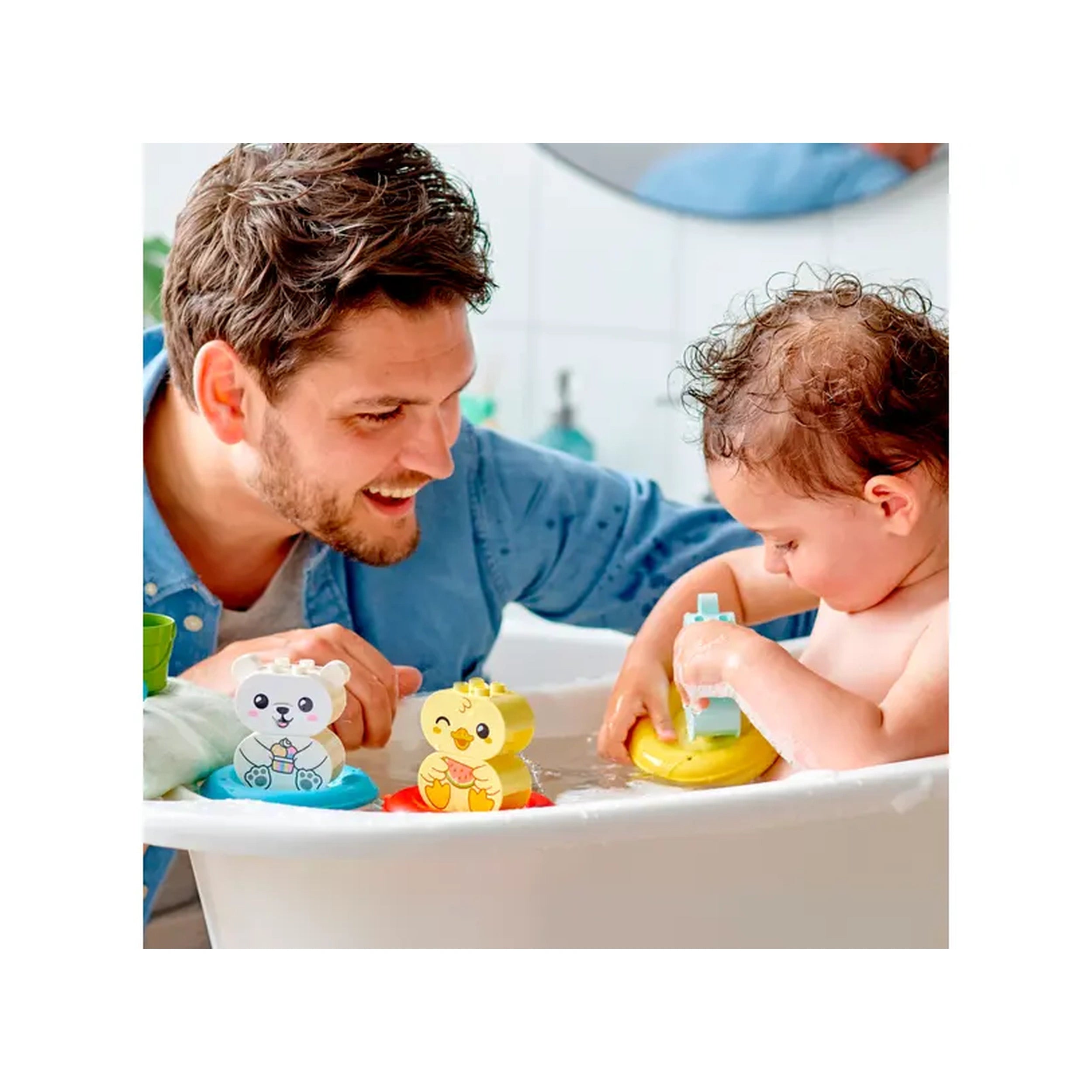 Father and toddler enjoying bath time with colorful LEGO DUPLO floating animal toys, including a bear and a duck, in a bright bathtub.