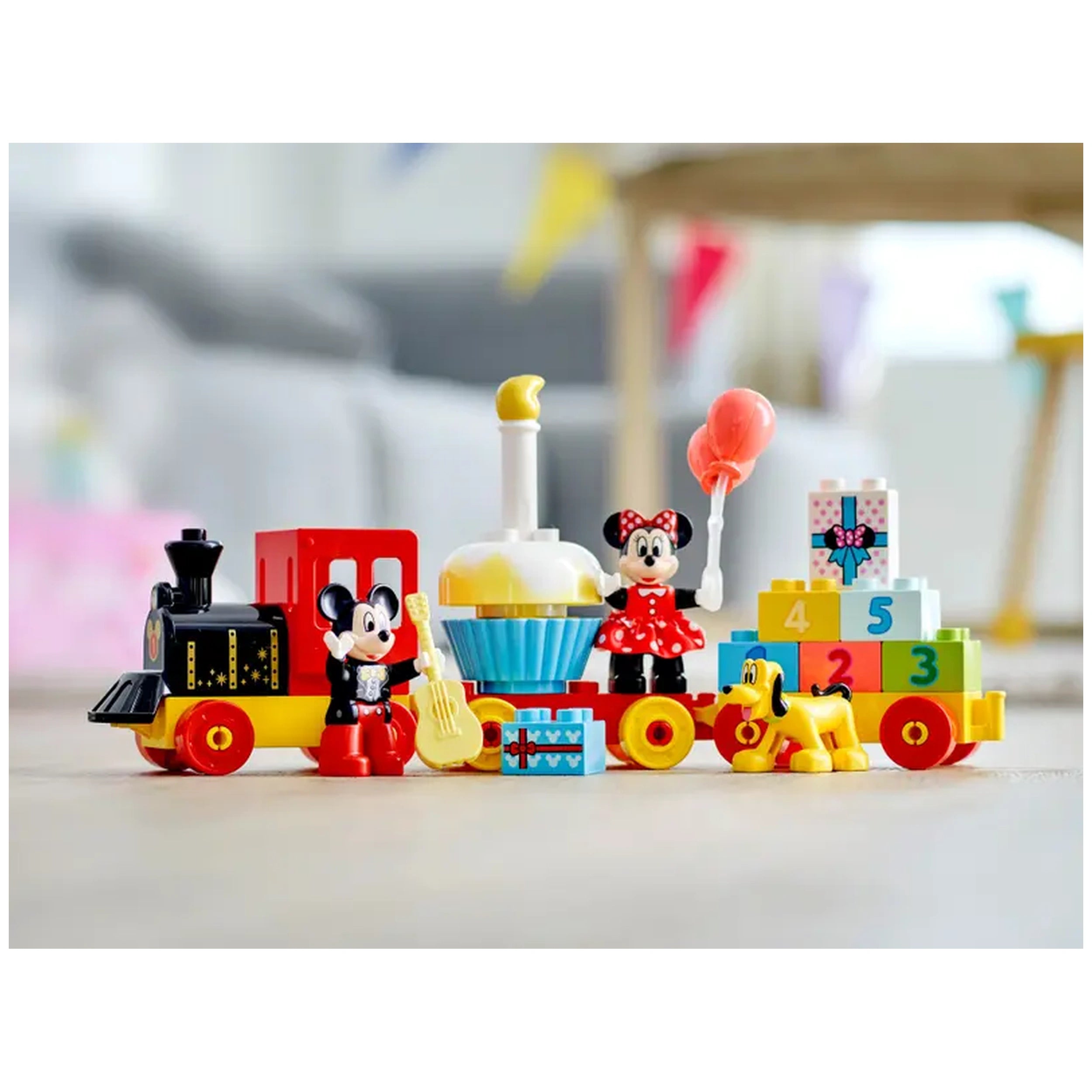 Colorful LEGO® DUPLO® Mickey & Minnie Birthday Train set featuring Mickey Mouse and Minnie Mouse holding a balloon, alongside playful train wagons, cake, and Pluto, all designed for toddler's imaginative play and fine motor skills development.