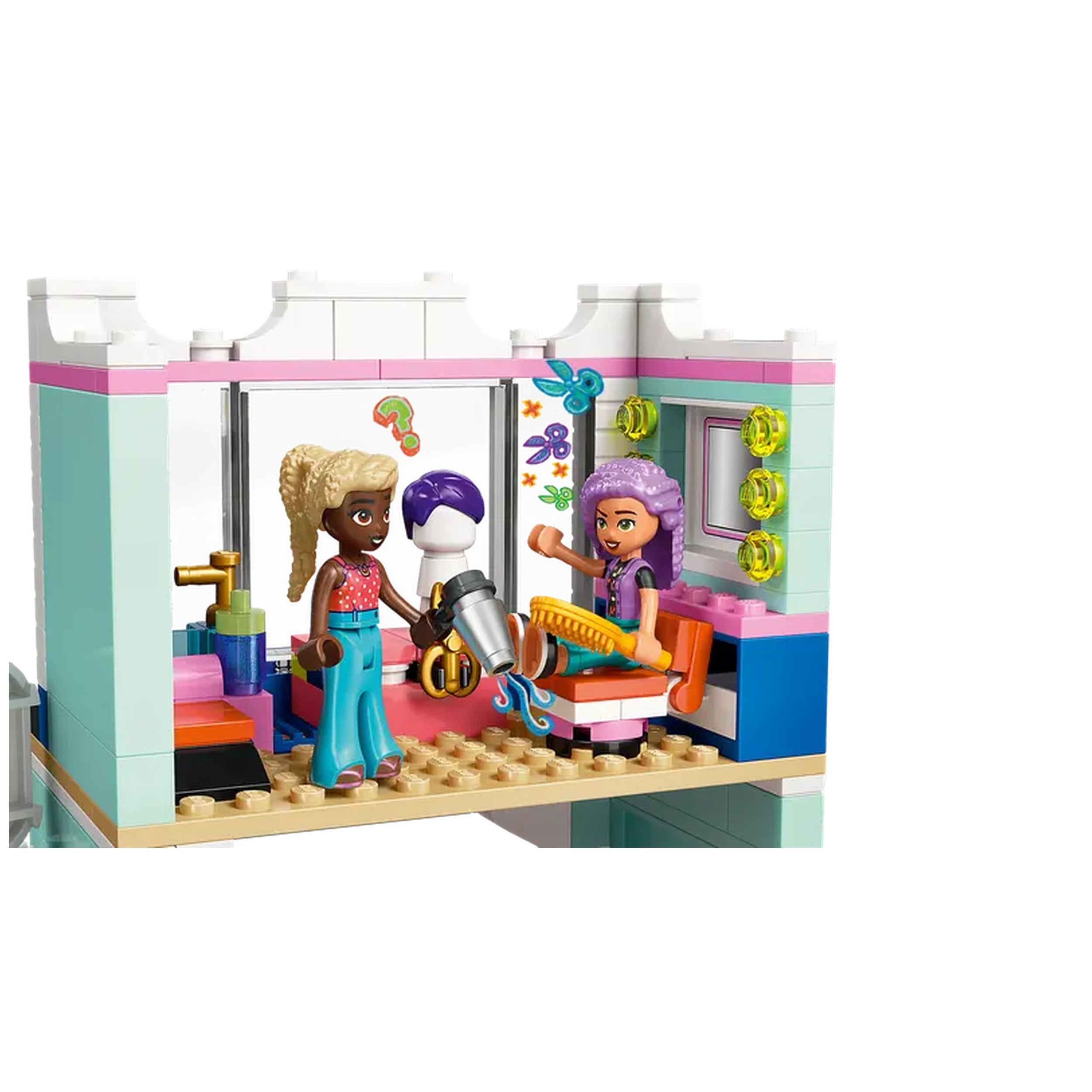 LEGO Friends Hair Salon featuring three mini-dolls at a two-story salon setup. One doll holds a hairdryer, while another styles a mannequin's hair. Bright colors, a styling chair, and decorative accessories create a playful atmosphere.