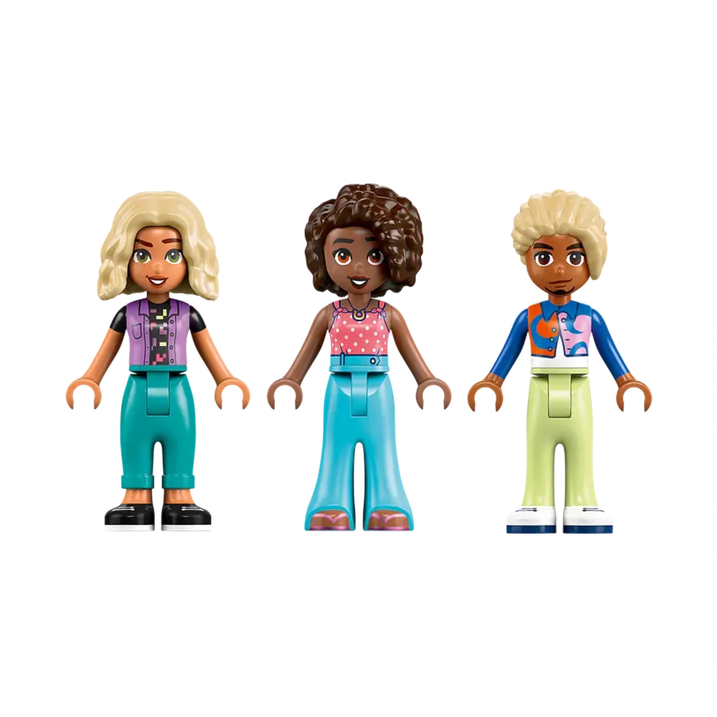 Three LEGO Friends mini-dolls stand side by side, each dressed in colorful outfits. On the left, a girl with blonde hair wears a purple vest over a black shirt and turquoise pants. In the center, a girl with curly brown hair sports a pink blouse with polka dots and matching turquoise trousers. On the right, a boy with short, light blonde hair is dressed in a blue and orange shirt with green pants. Their cheerful expressions and unique styles encourage imaginative play.