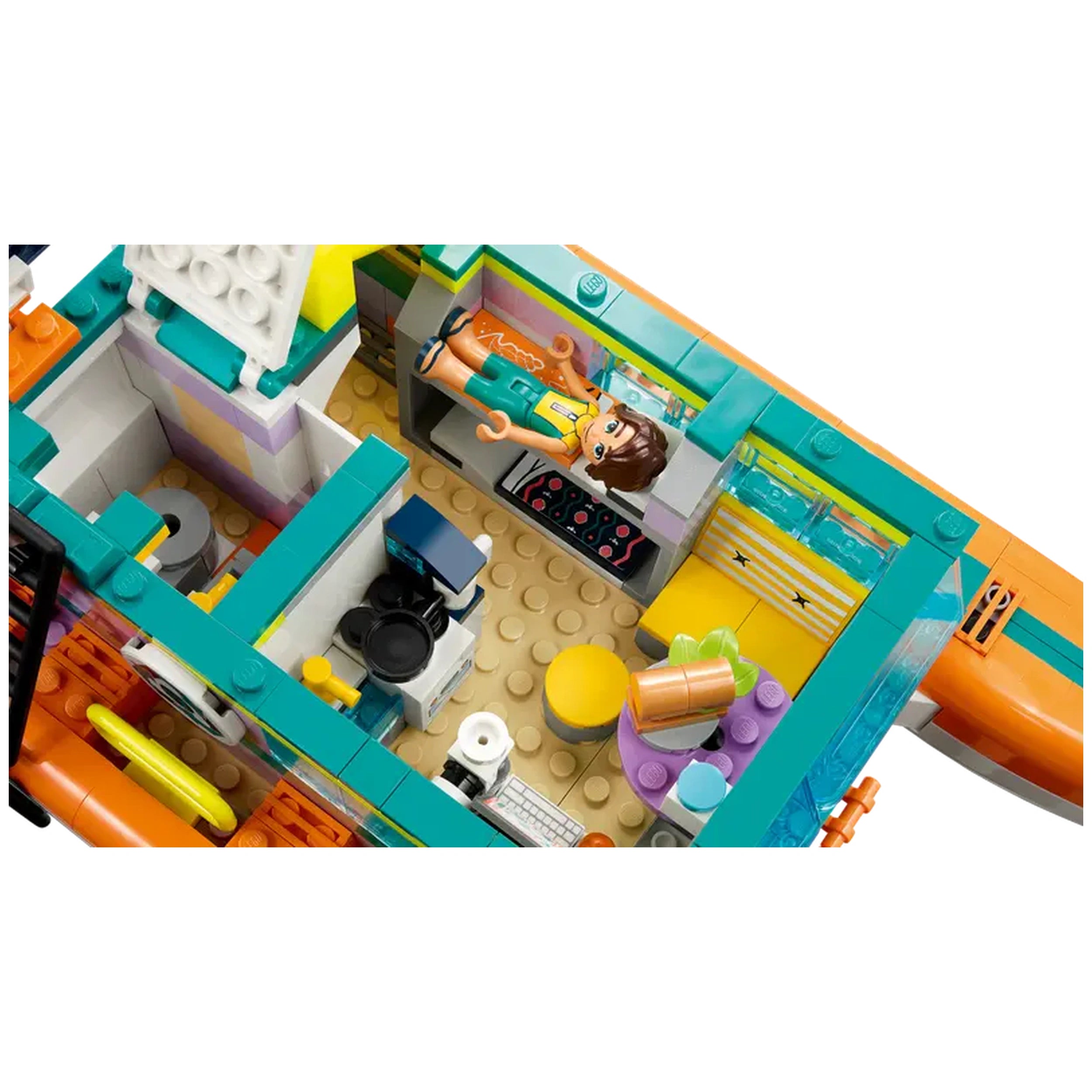 Colorful interior of the LEGO® Friends Sea Rescue Boat set featuring a catamaran’s living space with a mini-figure, lab equipment, and a yellow chair.