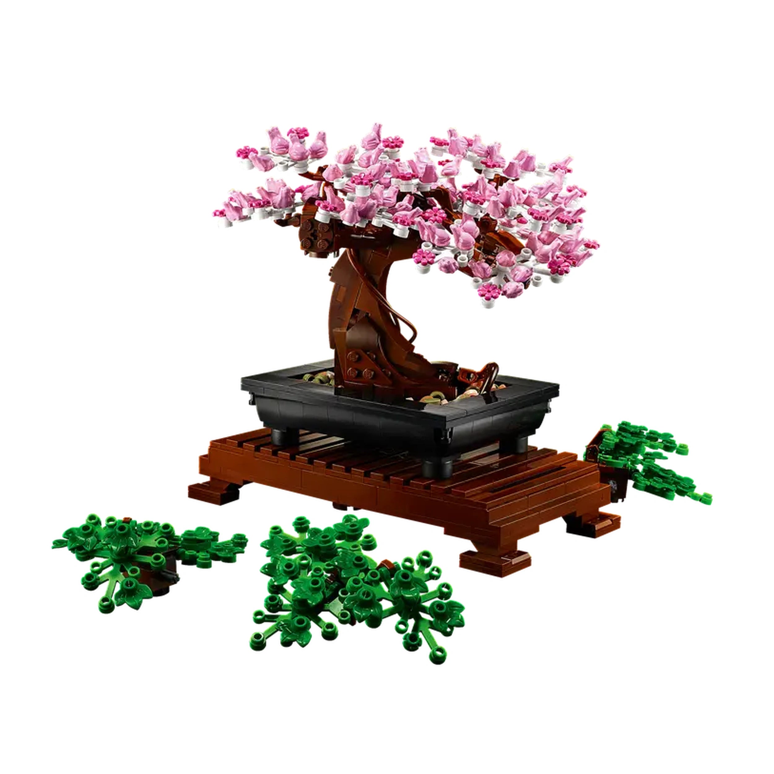 LEGO® Icons Bonsai Tree set features a detailed brown trunk adorned with pink blossoms, placed in a black pot on a wooden stand, surrounded by green leaf elements.