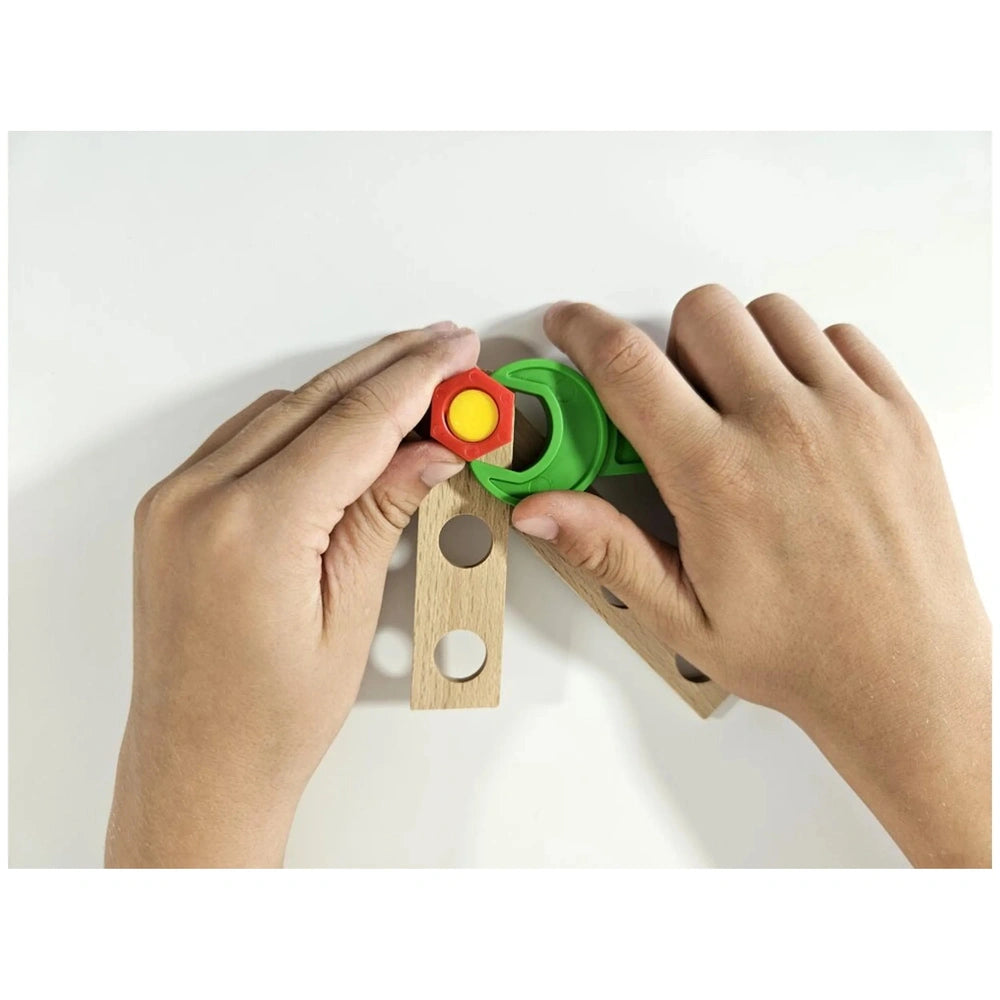 Child's hands assembling wooden toy helicopter with colorful screws and green connectors from Alexander Constructor Junior set.