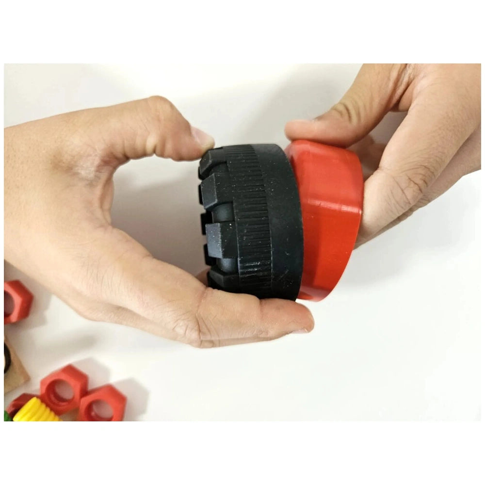 Hands holding a red and black component from the Alexander Junior Race Car Construction Set.