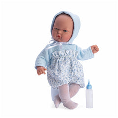 ASI Dolls Lalka Oli, 30 cm, in blue flowered dress with matching bonnet, white tights, and a bottle beside.