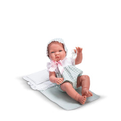 Charming Asi Dolls Pablo, 43 cm, in mint gingham dungarees and bonnet, sitting on a white blanket, holding a pacifier.