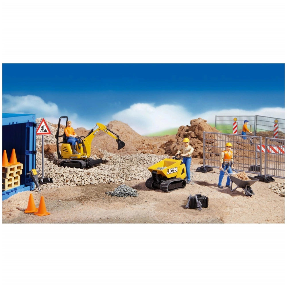 Construction play scene with toy figures, yellow digger, JCB truck, safety barriers, and tools on gravel under a blue sky.