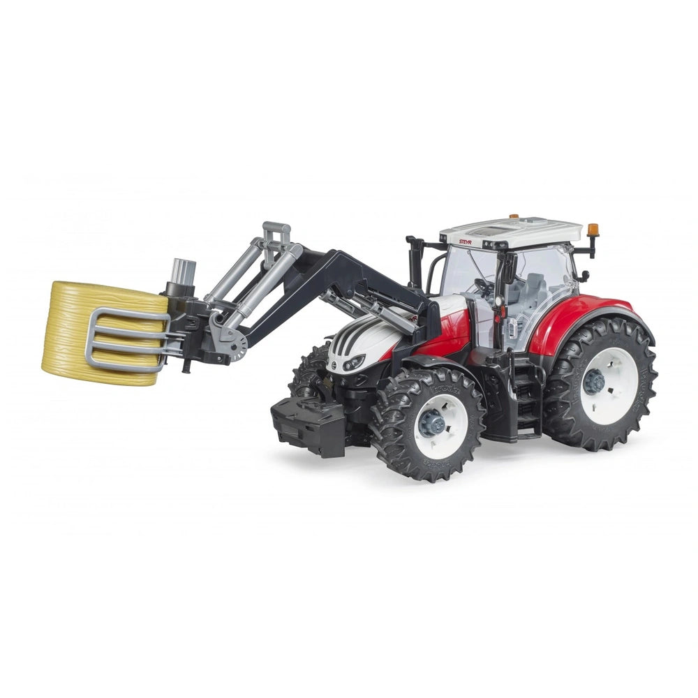 Red and white toy tractor with a black bale gripper holding a yellow round bale, designed for realistic farming play.