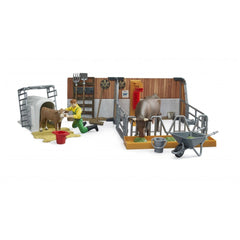 Farmer tending calf in barn set with cow, feed trough, red bucket, and wheelbarrow from Bruder's Bworld collection.