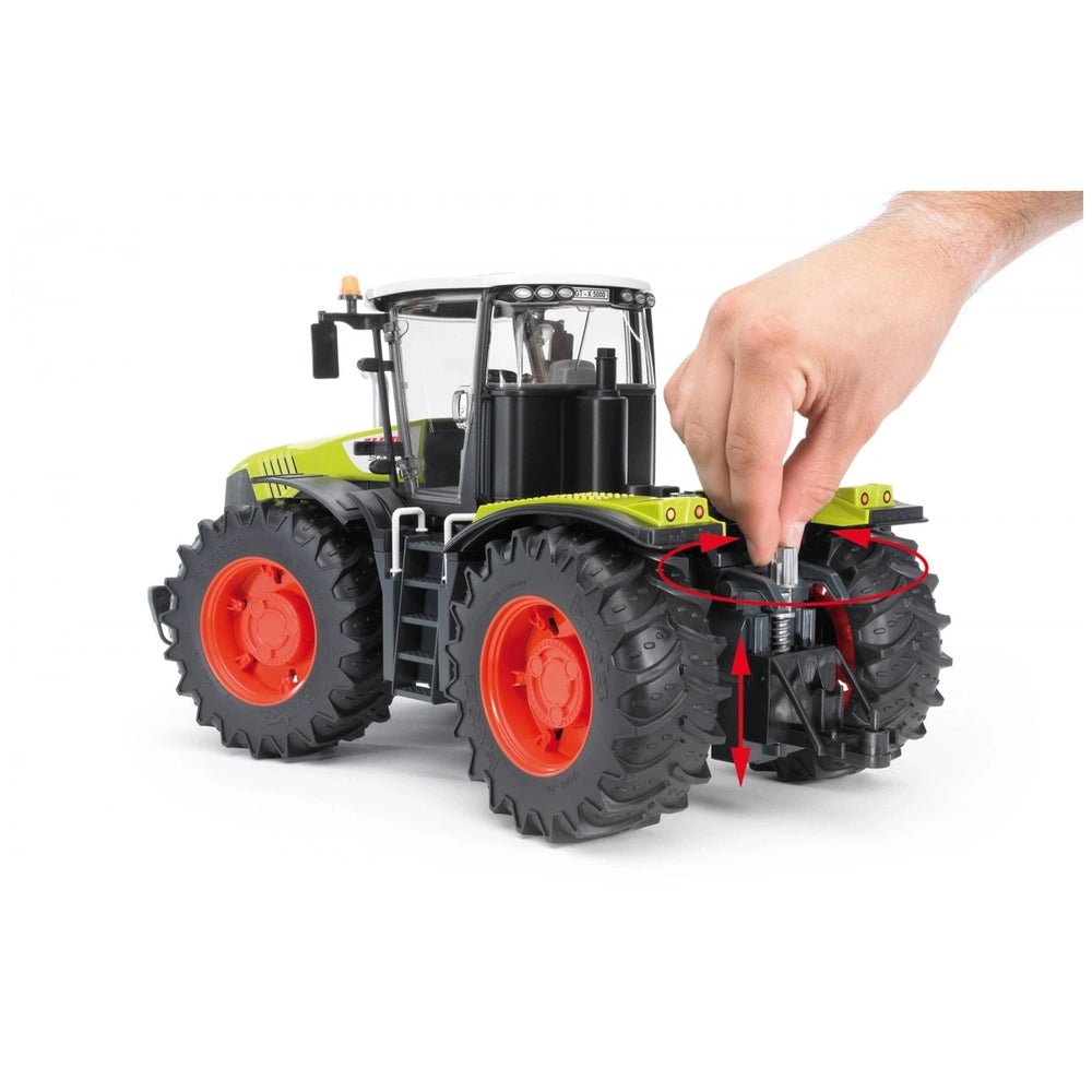 Toy Claas Xerion 5000 tractor with a hand demonstrating steering control.
