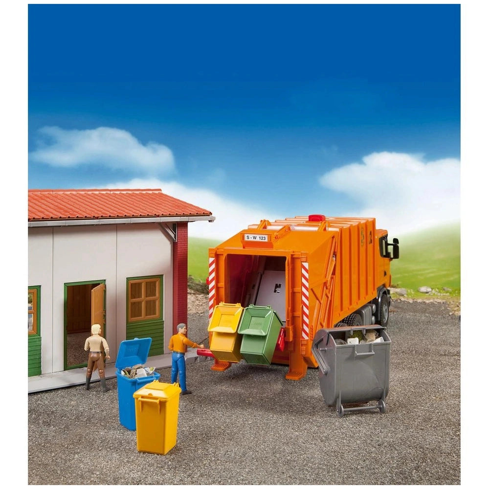 Toy garbage truck with colorful bins beside a small building, featuring miniature figures simulating waste collection.
