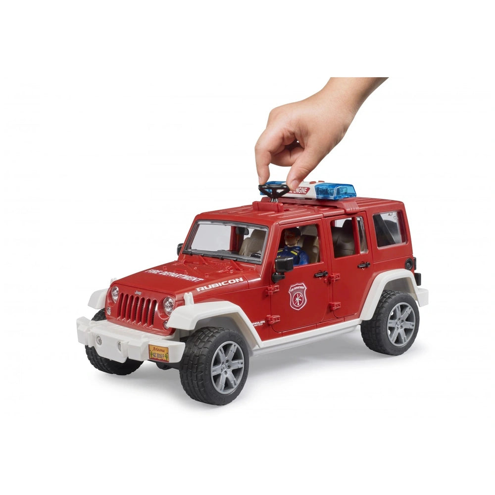 Red Jeep Wrangler Fire Department toy with white accents, blue light bar, and a hand turning a knob on the roof.