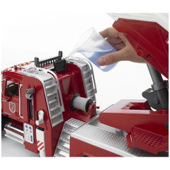 Hand pouring water into the red Bruder Mack Granite Fire Engine's operational water tank.