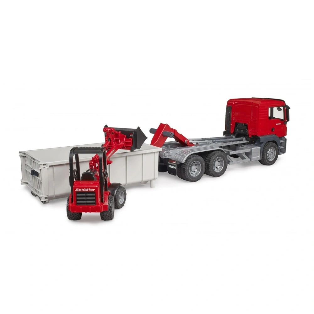 Red MAN TGS truck with roll-off container and red Schäffer yard loader beside it.