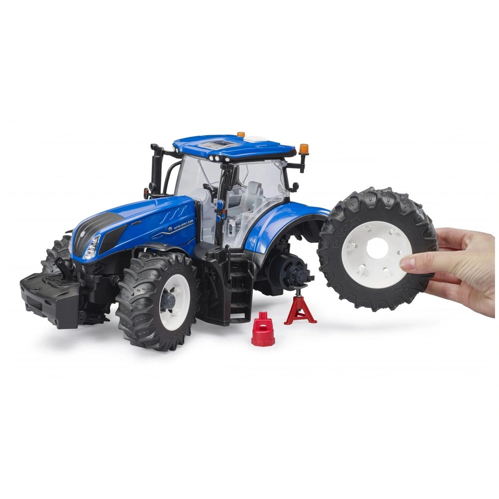 Blue toy tractor with removable wheel, detailed interior cab, and foldable bonnet; a hand holds a spare tire.