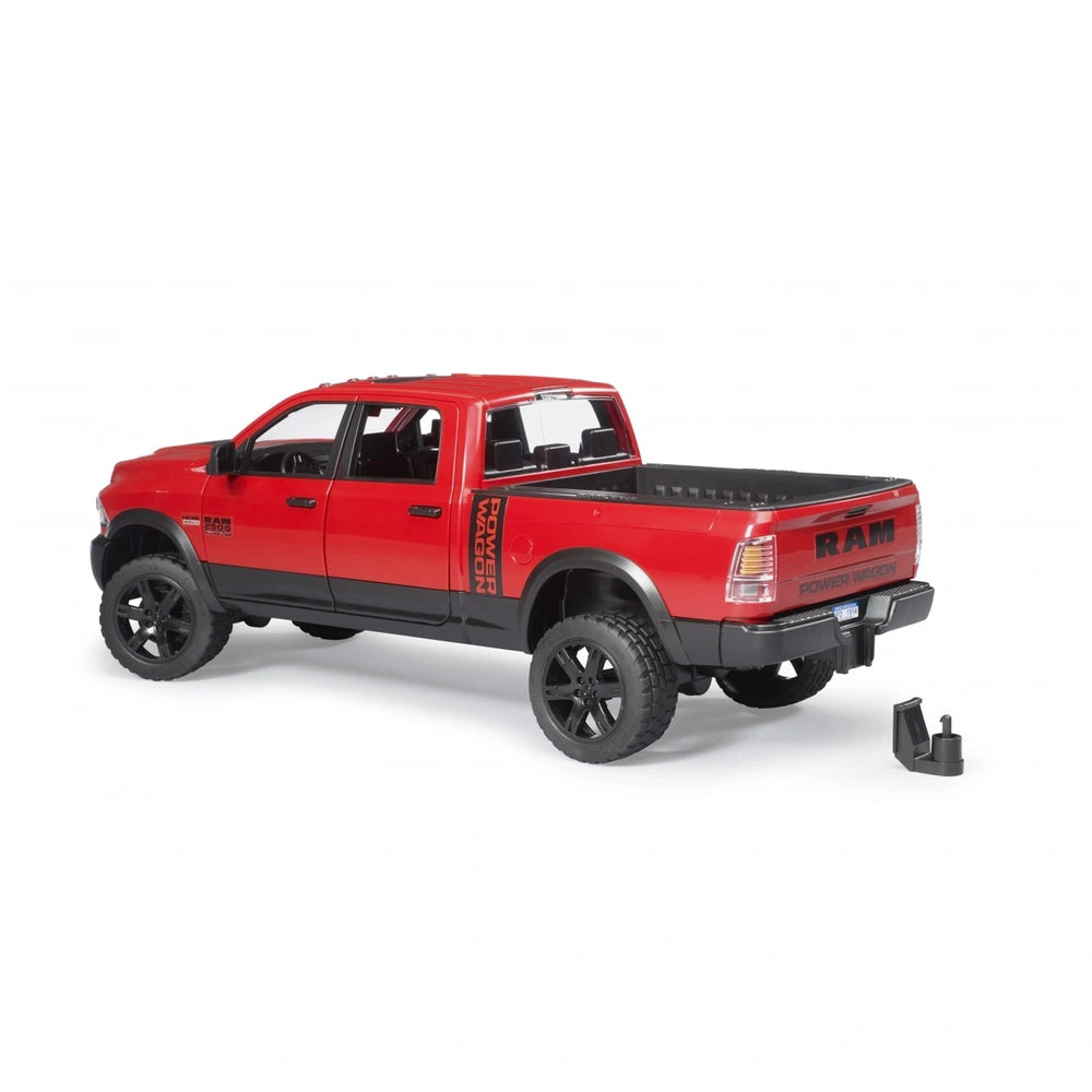 Red Bruder RAM 2500 Power Wagon toy truck with black wheels, shown from the rear side on a white background.