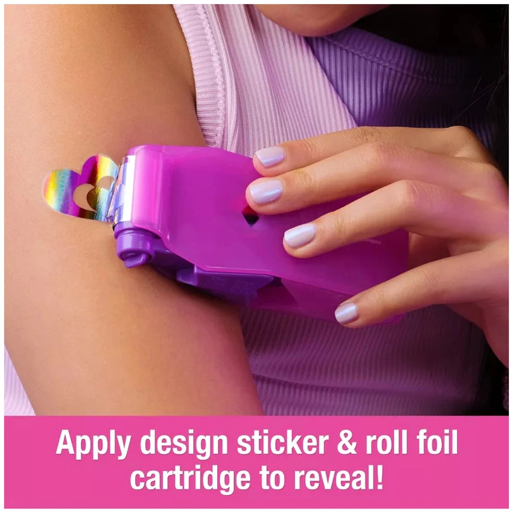 Cool Maker Shimmer Me Body Art Set device in purple held by a person with a tattoo, showcasing colorful design application in