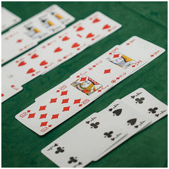 Dal Negro Premium Burraco cards in red and black designs arranged on a green surface, showcasing a smooth cardstock finish.
