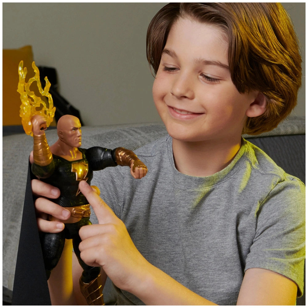 DC Comics Black Adam action figure is held by a smiling boy indoors, showcasing its glossy finish and dark costume with gold