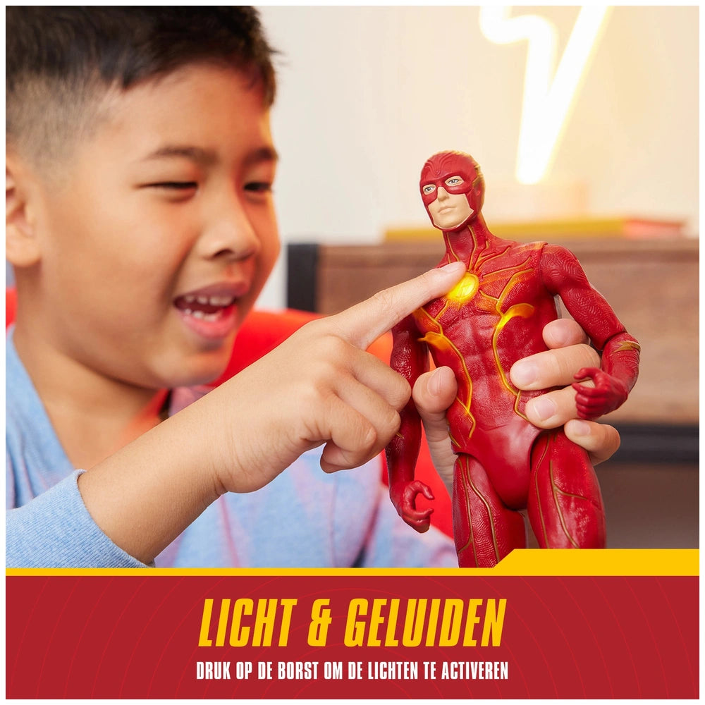 The Flash action figure with red and yellow details is being enthusiastically held by a smiling boy in a blue shirt.