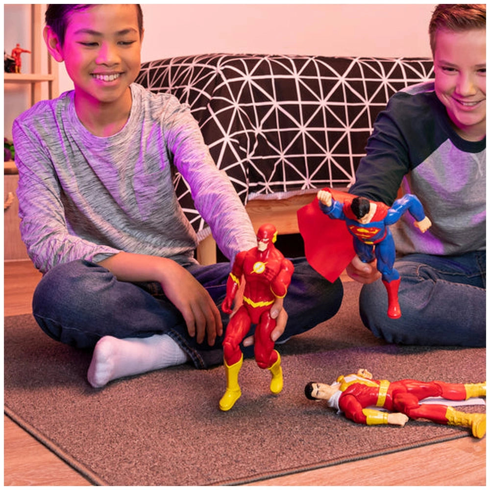 DC Comics The Flash action figure is held by two young boys playing on a carpeted floor in a purple-lit room.