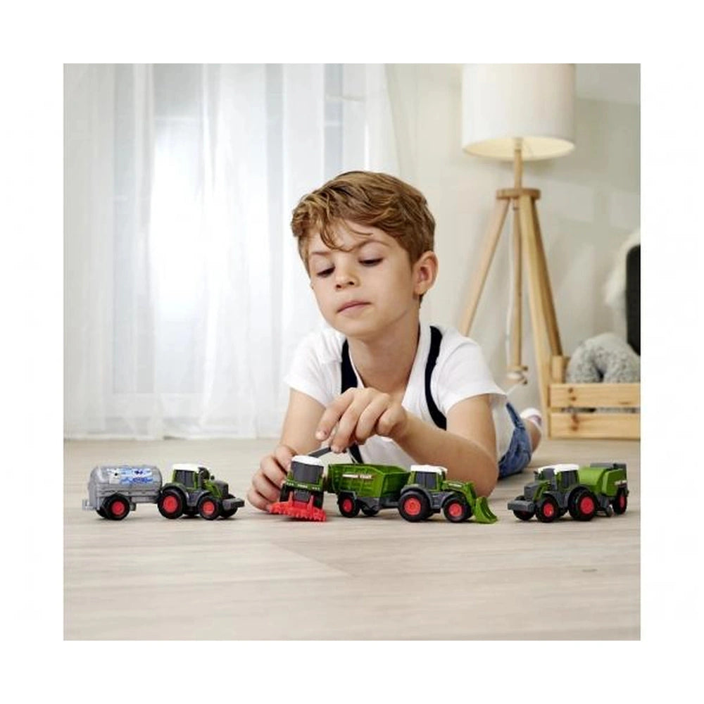 Fendt Micro Team play vehicles in a lifestyle scene with a young boy in a white t-shirt playing on light wood flooring.