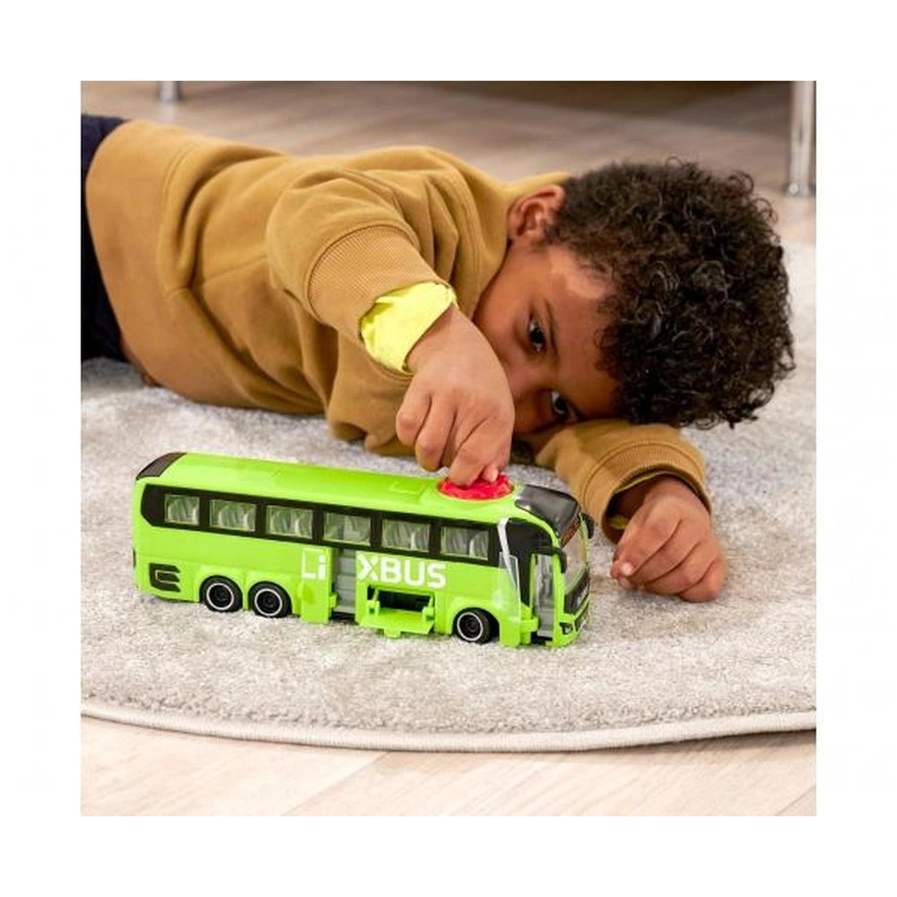 Dickie Man Lions Coach Flixbus toy bus in green and black, with a child in a brown sweatshirt interacting on light carpet.