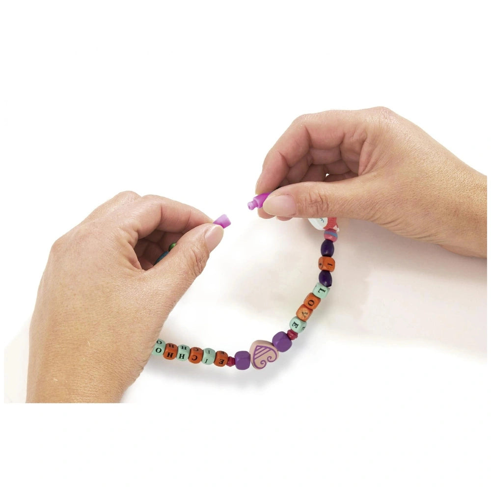 Eichhorn Bead Set Letters with 190 colorful plastic beads, featuring a purple bead at one end and a pink bead being held.