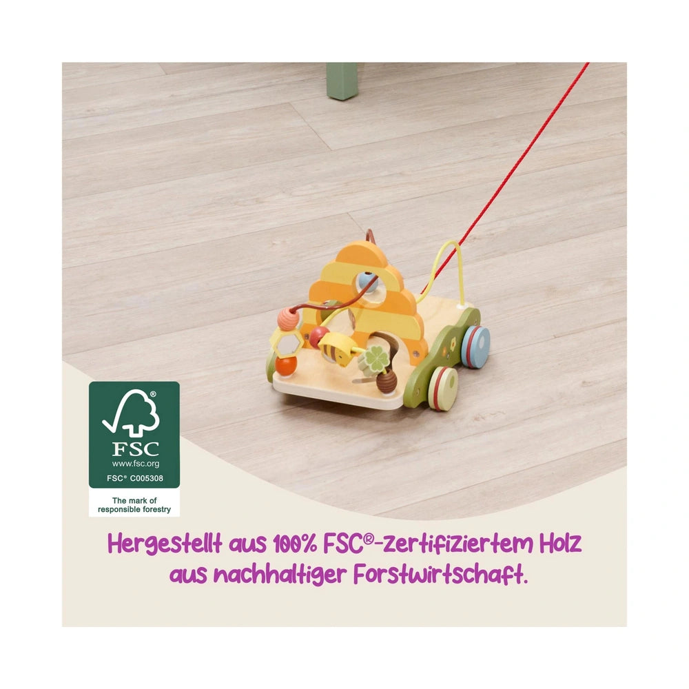 Bee Happy Pullalong Wagon in bright colors on a wooden floor, designed for children with a friendly face and wheels.