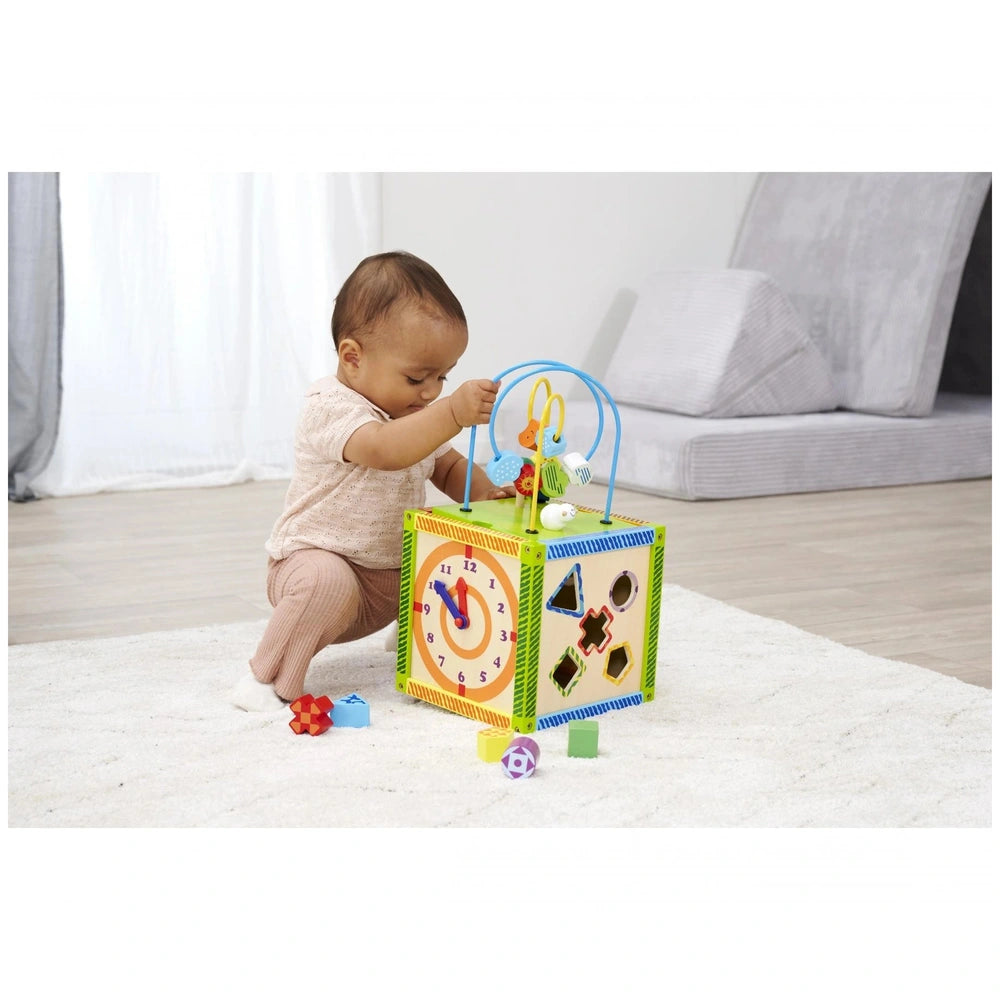 Eichhorn Color Little Play Center features a colorful child-sized clock toy with buttons, as a young child plays on a white c
