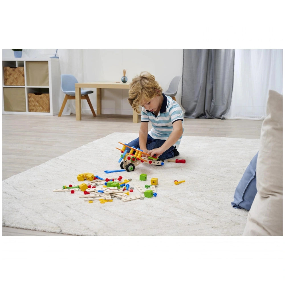 Eichhorn Constructor 4 in 1 construction set toys are being played with by a young boy on a light-colored rug indoors.