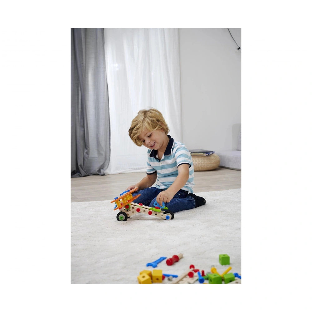 Eichhorn Constructor 4 in 1 construction set is being enjoyed by a smiling young boy sitting on a carpeted floor.