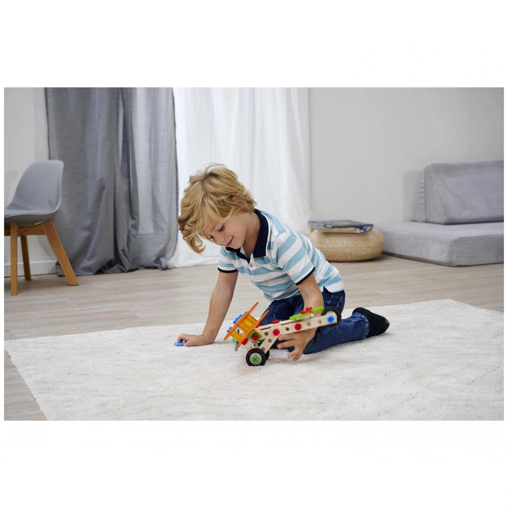 Eichhorn Constructor 4 in 1 construction set with colorful pieces being played with by a child on a white carpet.