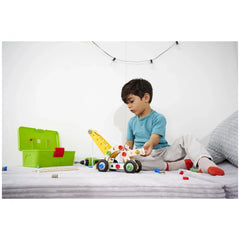 Eichhorn Constructor 4in1 construction set toys displayed as a child in blue shirt plays on a bed with colorful toys nearby.