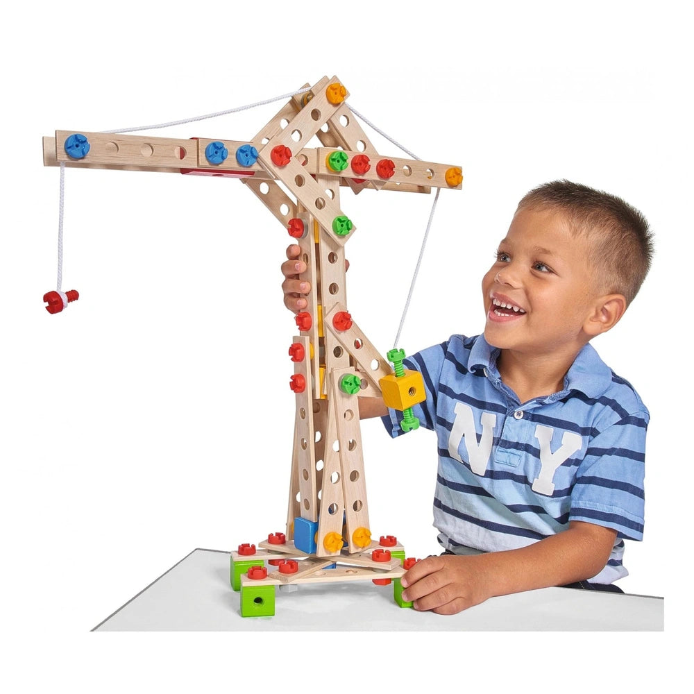 Eichhorn Constructor 5 in 1 construction set featuring a wooden crane with colorful plastic connectors, held by a young boy.