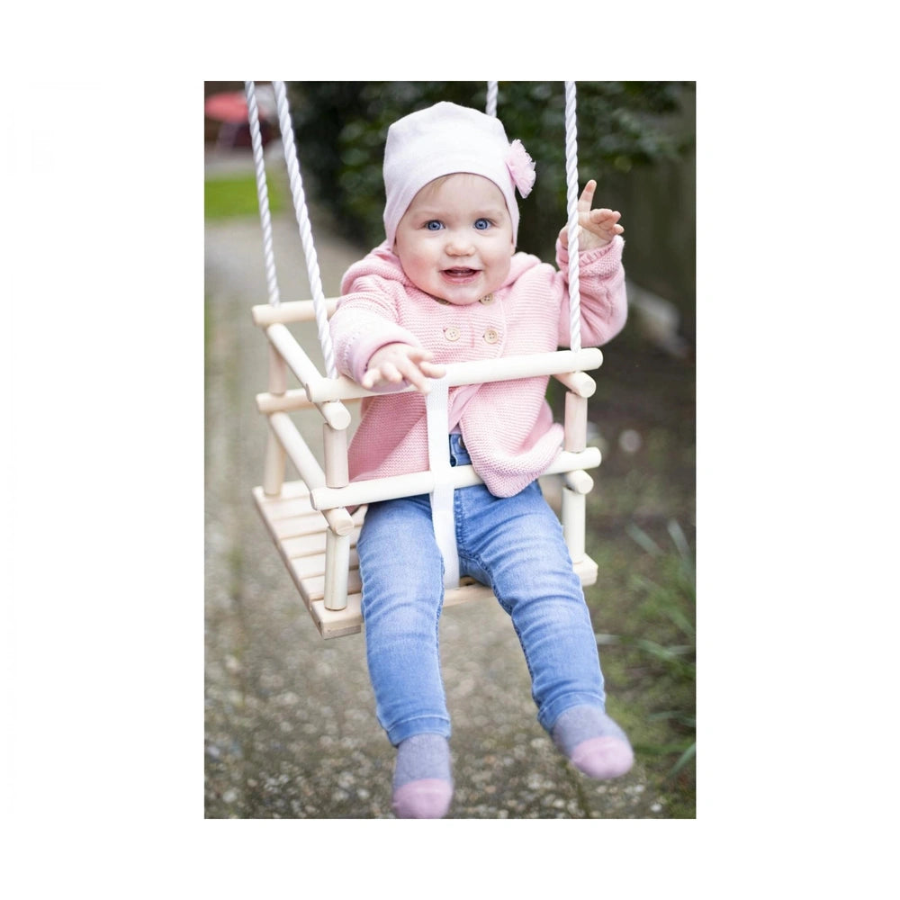 Eichhorn Outdoor Wooden Baby Swing featuring a smiling child in a pink sweater enjoying a natural outdoor setting.
