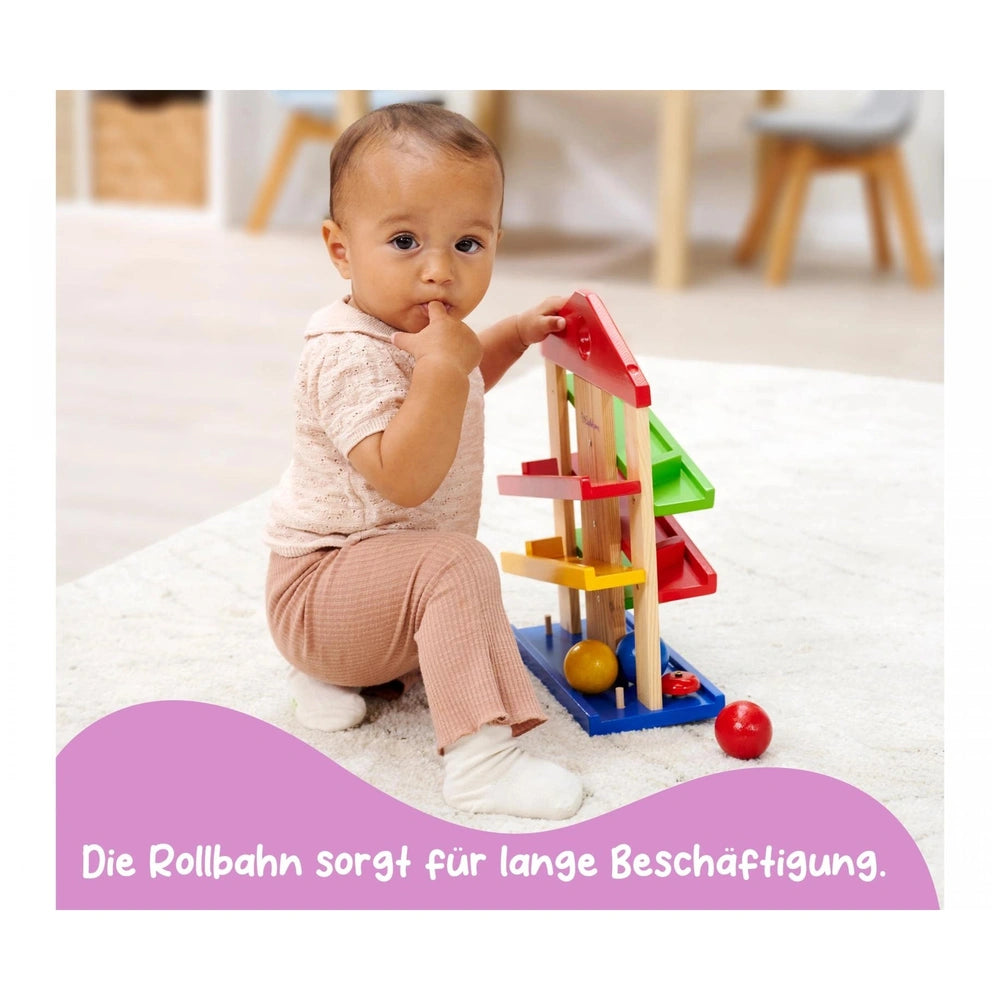 Eichhorn Runway Baby Activity Toys: A child interacts with a colorful wooden toy featuring various blocks and a red ball.