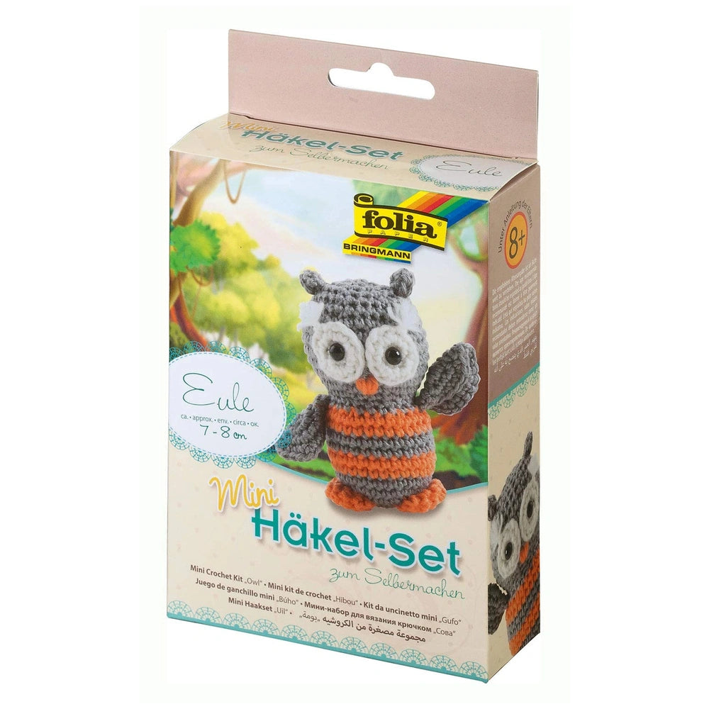 Folia Mini Crochet Kit features a gray owl with orange and white accents, visible crochet hook, and clear plastic window on m