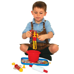 Gowi Baking Set Salzburg 17 pieces features a red suspender, blue sweater, and colorful plastic toys arranged centrally.