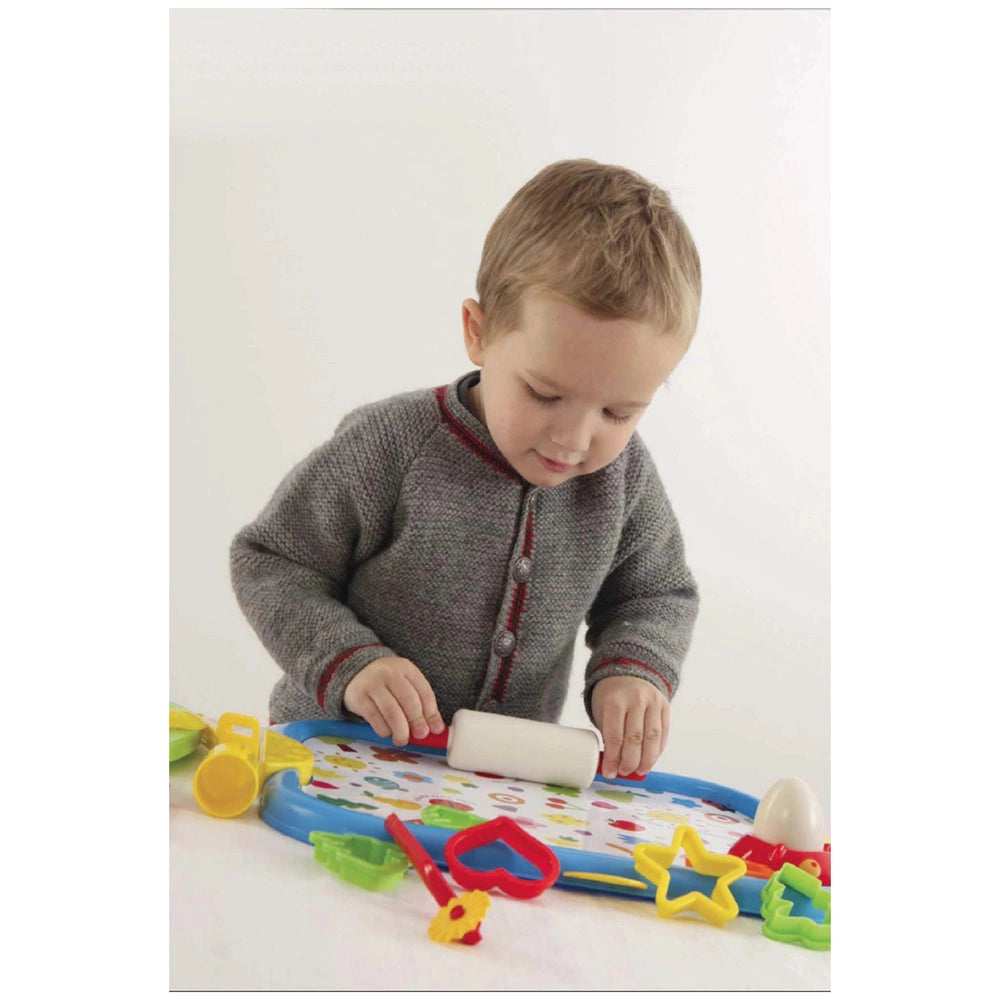 Gowi Baking Set with a young child in a gray sweater, colorful toys on a blue table, featuring a white object with a red hand
