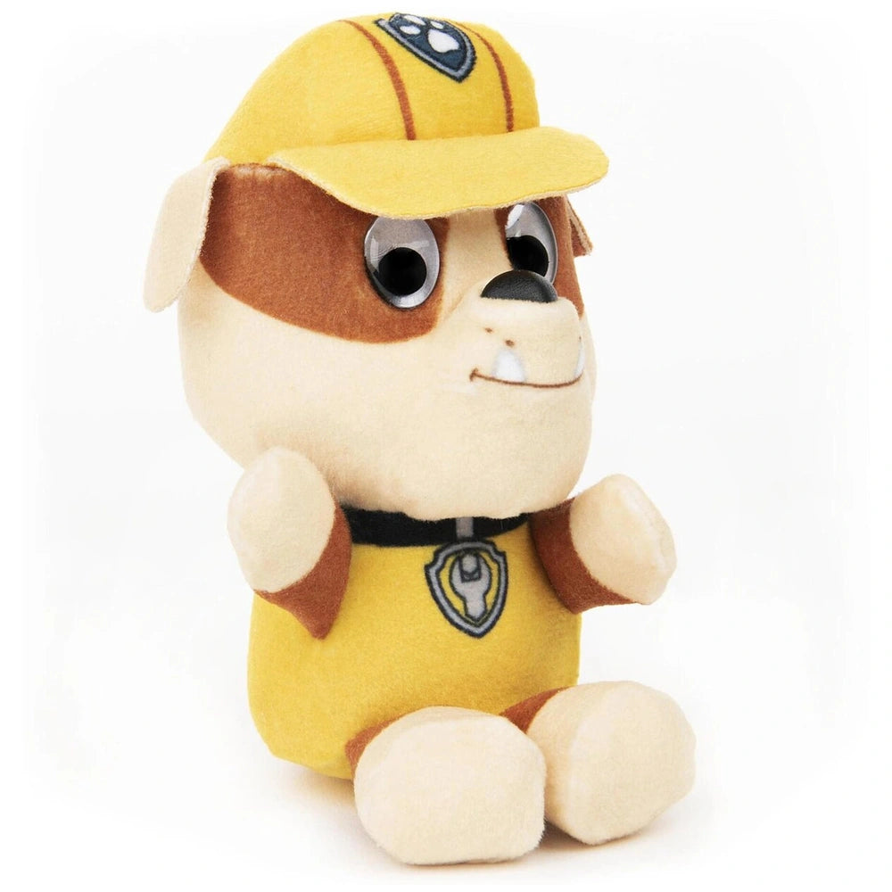 GUND PAW Patrol plush toy features a smiling yellow dog with brown accents, wearing a cap and a shiny badge on its chest.