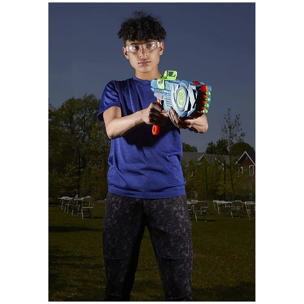 Nerf Elite 2.0 Flipshots Flip-8 Blaster held by a person in a blue t-shirt and patterned pants, standing on grass with a hous